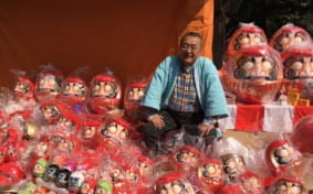 Man with lots of daruma