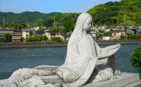 Statue of Murasaki Shikibu in front of the river