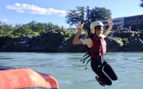 Smiling girl jumping into river