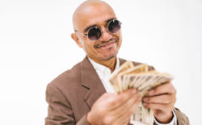 man smiling at the Japanese yen notes in his hands